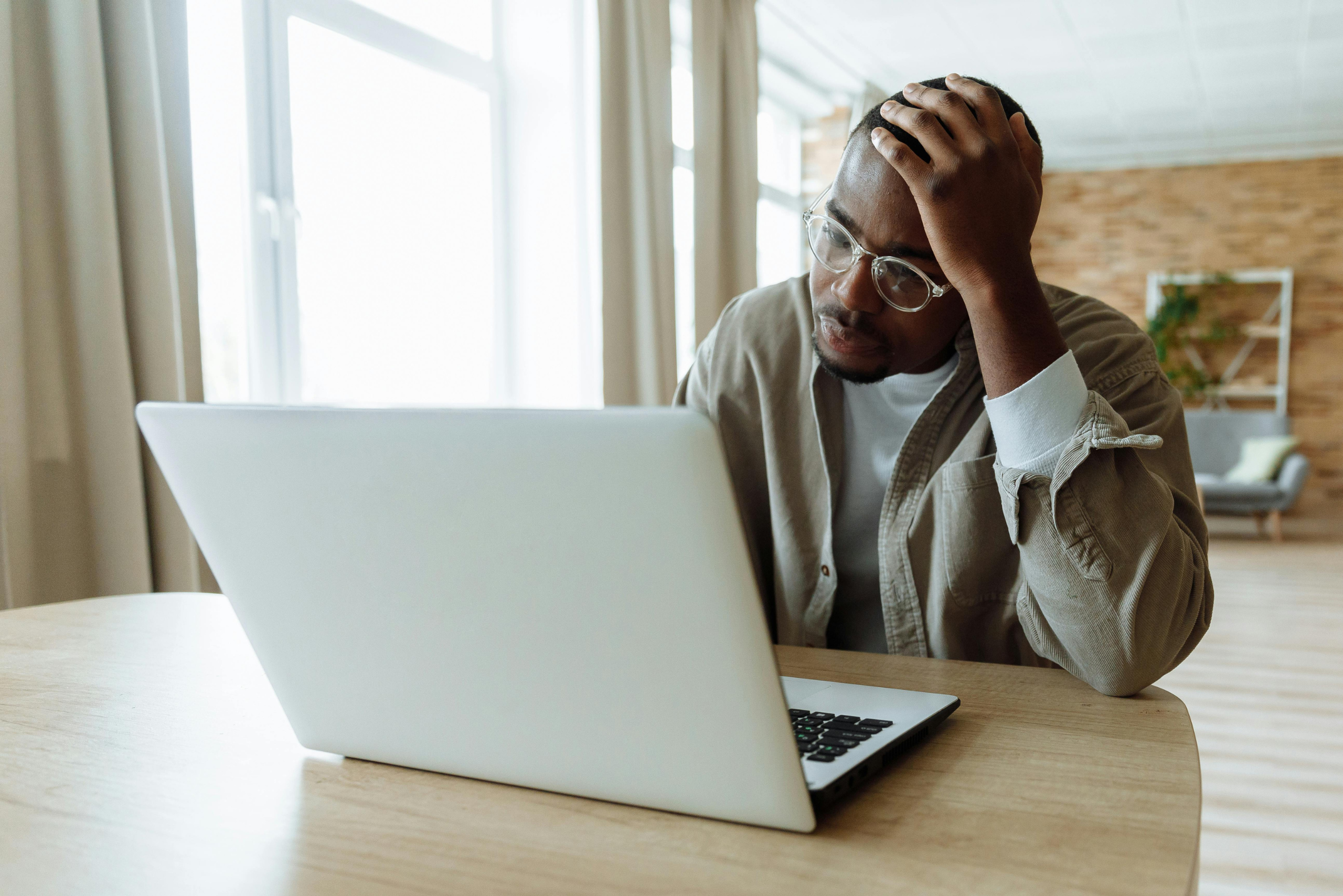 Homem preocupado utilizando notebook após possível vazamento de dados pessoais e problemas relacionados à privacidade digital.